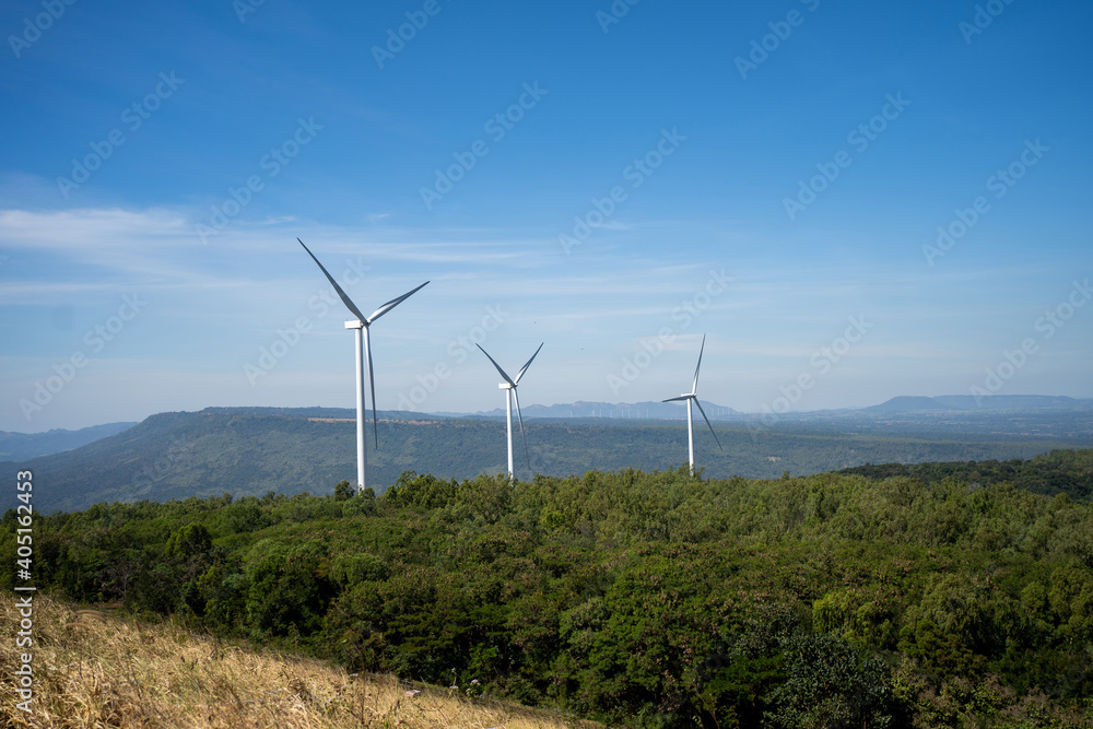 Wind turbines on green mountain over a cloudy blue sky. Wind turbines on green mountain over a cloudy blue sky.