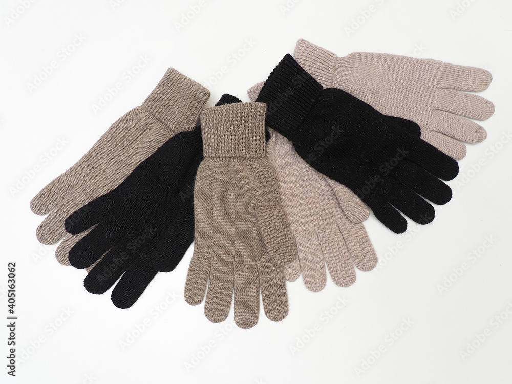 Warm woolen gloves of different colors on a white background. Warm woolen gloves of different colors on a white background.