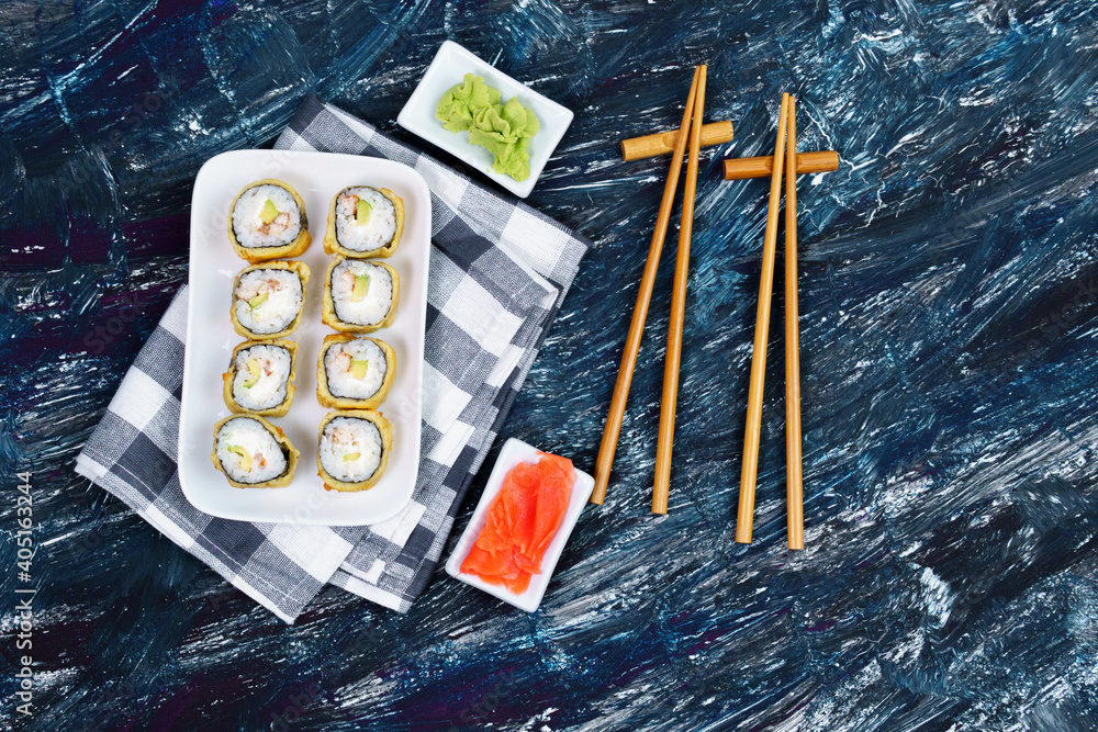 baked sushi rolls with wasabi and ginger on a black background. Japanese oriental cuisine. flat lay baked sushi rolls with wasabi and ginger on a black background. Japanese oriental cuisine. flat lay