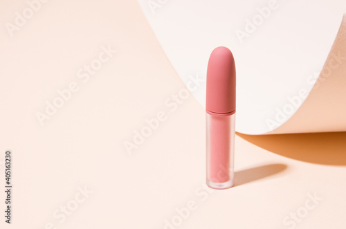 Matte lipstick lip gloss on a beige background. copy space