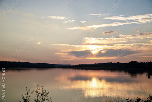 Beautiful lake view during sunset with blue and yellow sky reflection in water. Rural scene. Ecological protection and eco tourism concept. Natural landscape. Isolation in countryside.