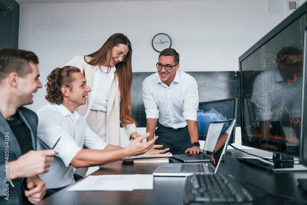 Attention to details. Team of stockbrokers works in modern office with many display screens Attention to details. Team of stockbrokers works in modern office with many display screens