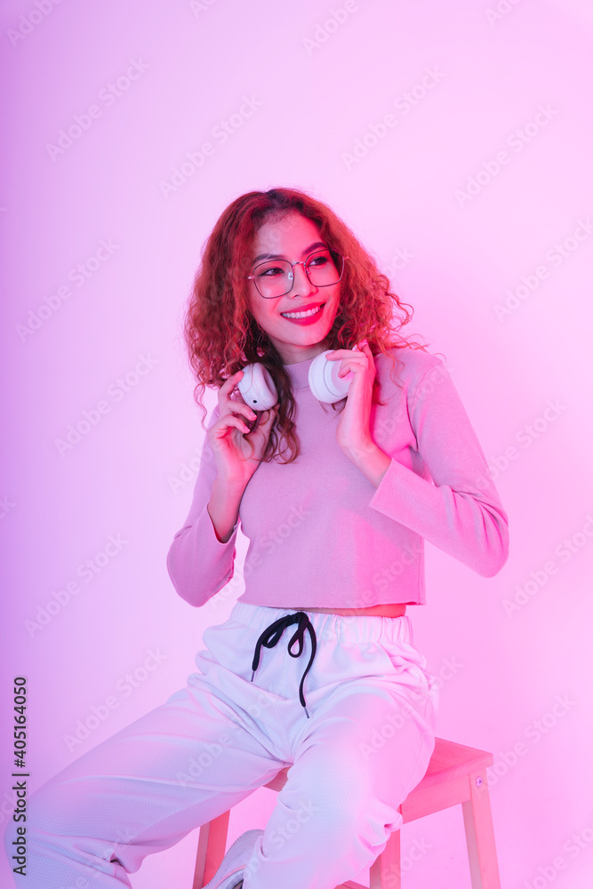 Asian beauty girl curly hair with wireless headphone in neon studio. Asian beauty girl curly hair with wireless headphone in neon studio.