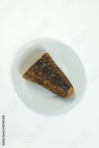 Stuffed carp fish. Jewish traditional whole gefilte fish cut served on plate isolated on white background. Minced fish fillet with vegetables in fish skin backed in oven. Dish isolated on white 