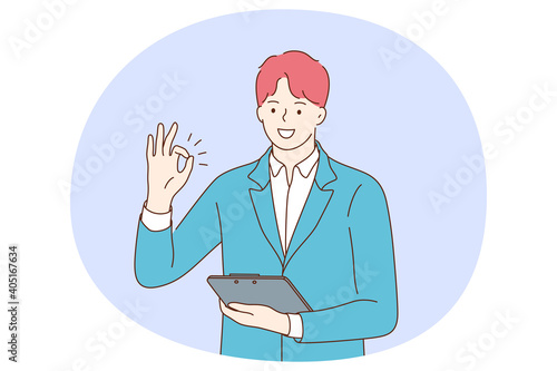 Positive emotions, ok sign and gesture language concept. Young positive businessman cartoon character standing with tablet or documents in hand and showing agree okay success sign with fingers 