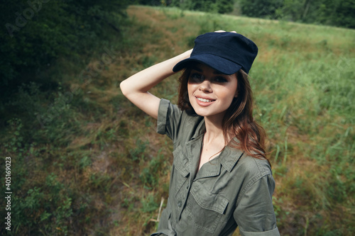 Woman in the forest Smile Look Forward green jumpsuit black cap summer 