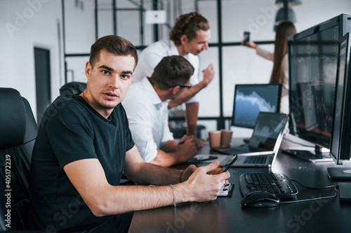 Team of stockbrokers works in modern office with many display screens