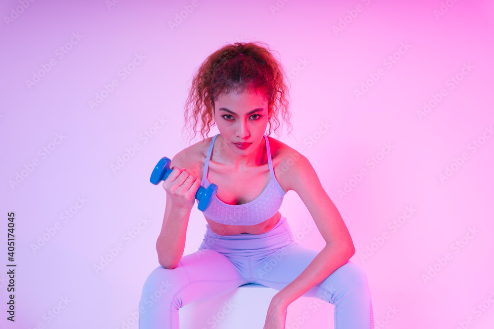 Healthy asian curly hair woman using dumbbells in gym studio. Healthy asian curly hair woman using dumbbells in gym studio.