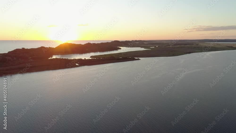 Aerial descent over Snowy River estuary facing the sun at sunset Aerial descent over Snowy River estuary facing the sun at sunset