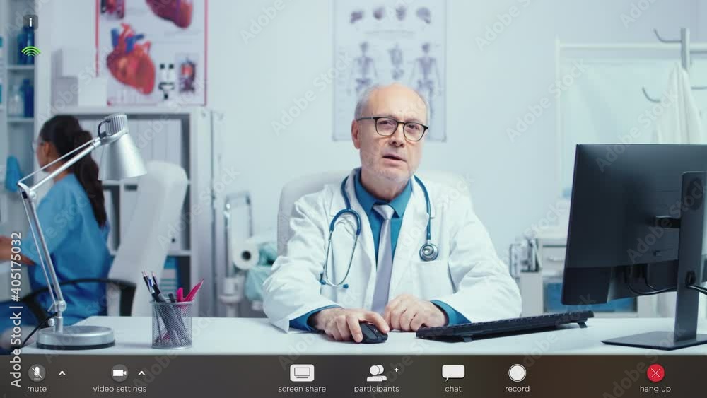 Senior authentic medical doctor offering online consultation during COVID-19 glabal pandemic. Working in health industry with virtual conference technology. Footage with software overlay concept Senior authentic medical doctor offering online consultation during COVID-19 glabal pandemic. Working in health industry with virtual conference technology. Footage with software overlay concept