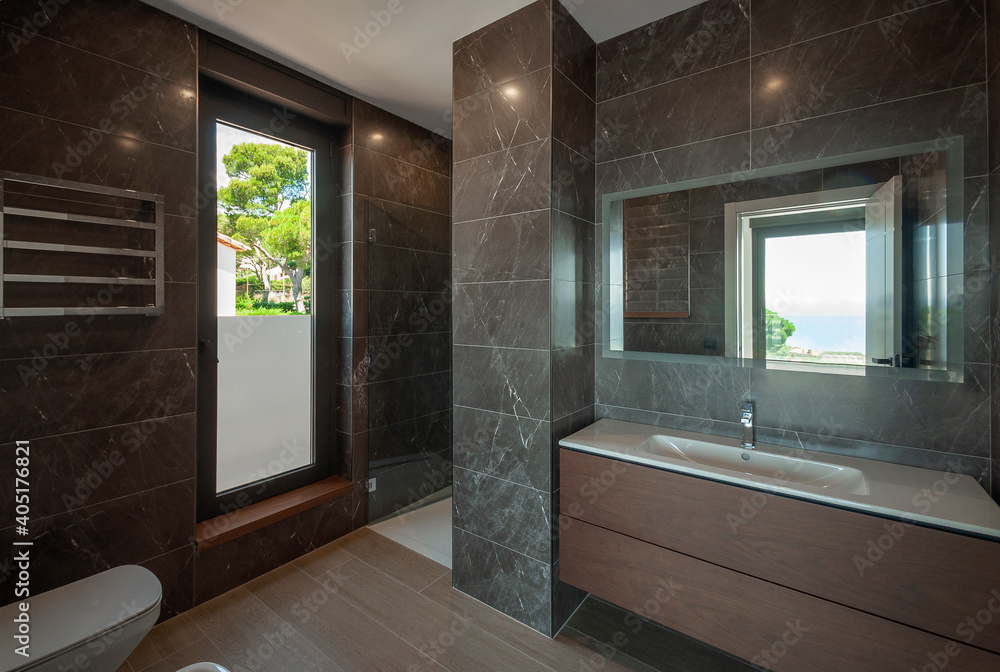 Modern bathroom with large window with modern washbasin.