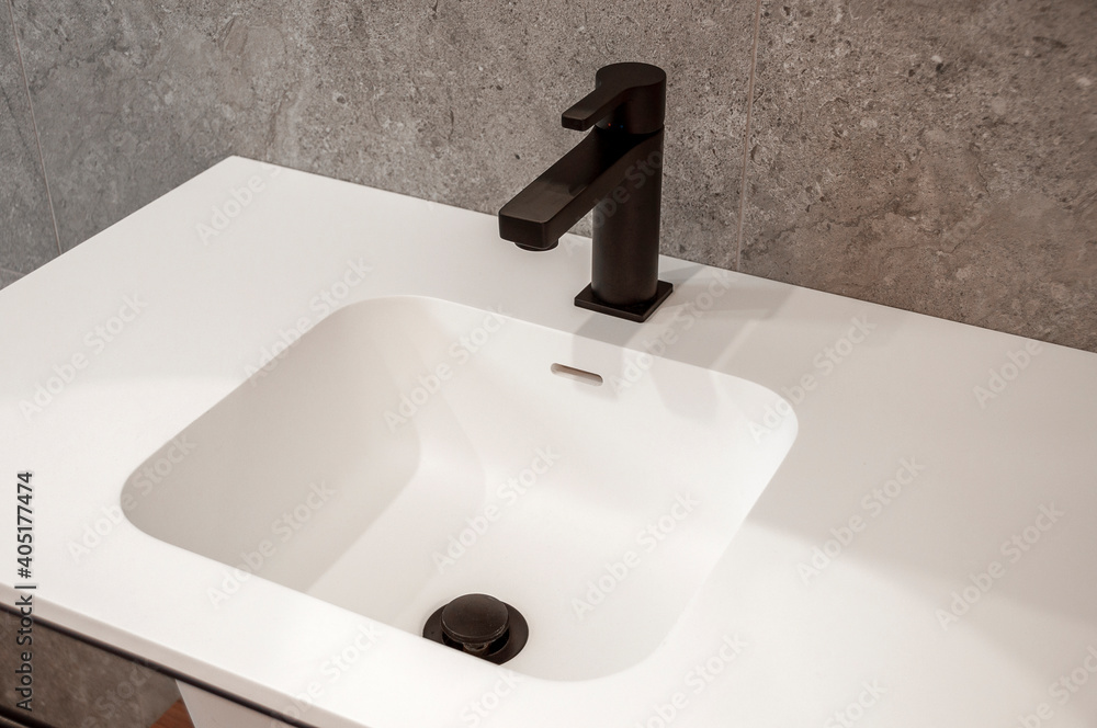 Fototapeta premium Modern white washbasin with mixer tap in bathroom.