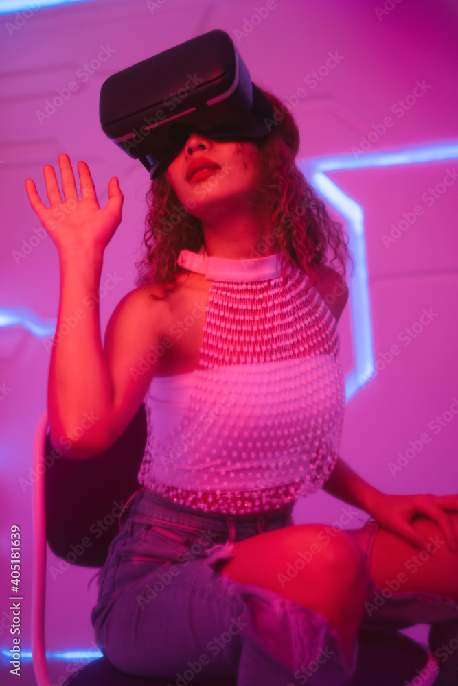 Model curly hair woman wear glasses of virtual reality VR in future room. Model curly hair woman wear glasses of virtual reality VR in future room.