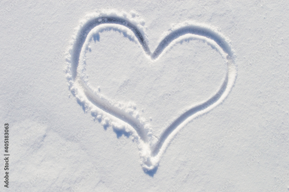 symbol of the heart, painted on the fresh white snow close up