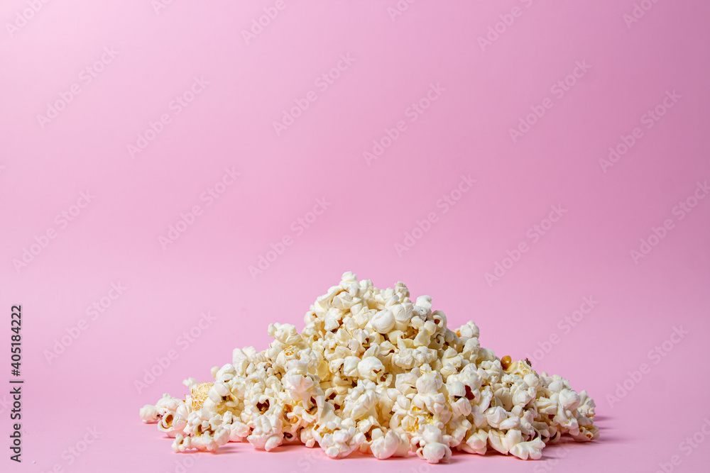 Popcorn on a pink background. Popcorn lies in a heap. Movie snack. Popcorn on a pink background. Popcorn lies in a heap. Movie snack.
