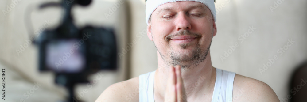 Obraz premium Handsome male person keeping smile on his face while shooting tutorials on his camera