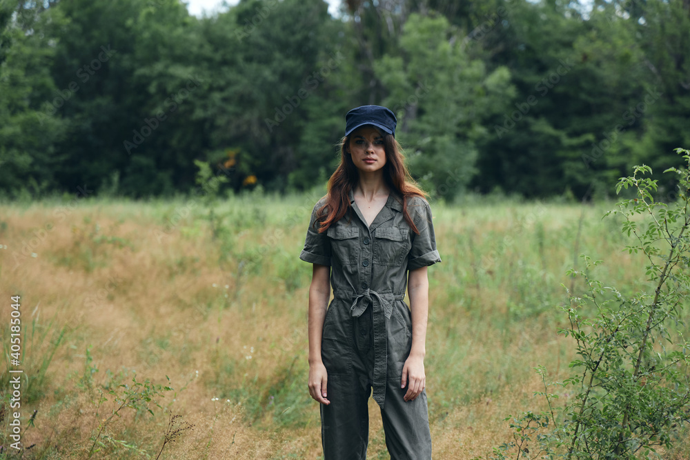  woman in nature in a gray overalls and a cap on her head