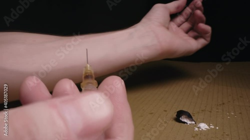 Heroin addict junkie injecting Syringe needle heroin into arm. Opiate addiction.