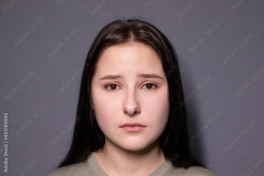 portrait of charming sad brunette woman in marsh color t-shirt on grey wall background. actress acting, emotion portrait of charming sad brunette woman in marsh color t-shirt on grey wall background. actress acting, emotion