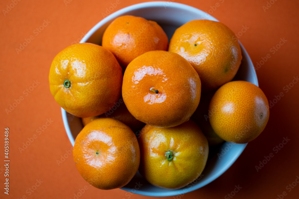 clementines in a bowl with orange background