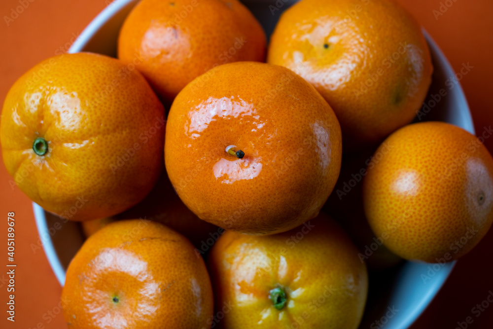 clementines in a bowl with orange background clementines in a bowl with orange background