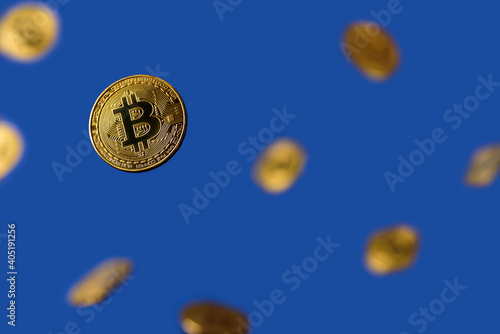 Many Bitcoins flying levitation on blue background