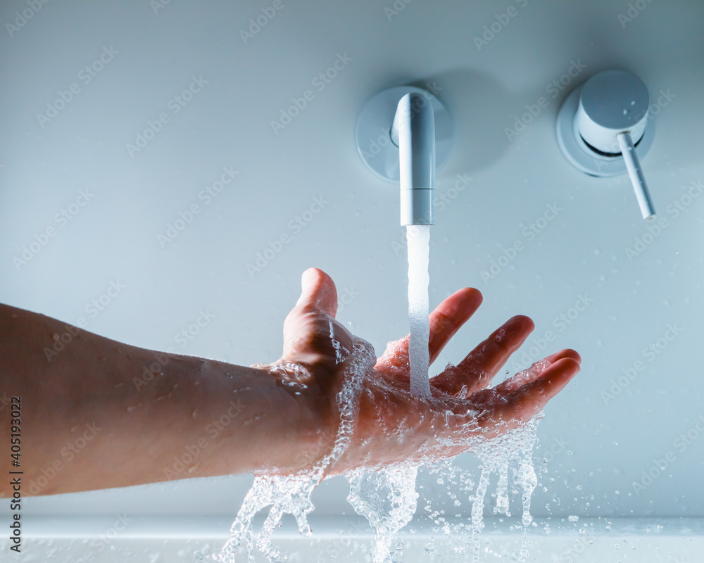 Fototapeta premium hand under the faucet with flowing water splash
