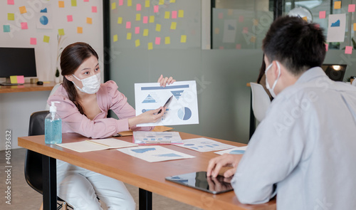 business worker meeting and brainstorm for startup new business. man and woman wear protective face mask in new normal office preventing coronavirus COVID-19 spreading. New normal business concept.