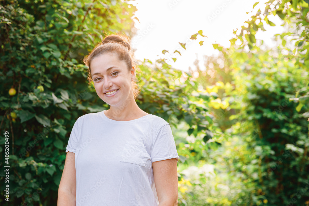 Happy girl smiling outdoor. Beautiful young brunete woman with brown hair resting on park or garden green background. European woman. Positive human emotion facial expression body language. Happy girl smiling outdoor. Beautiful young brunete woman with brown hair resting on park or garden green background. European woman. Positive human emotion facial expression body language.