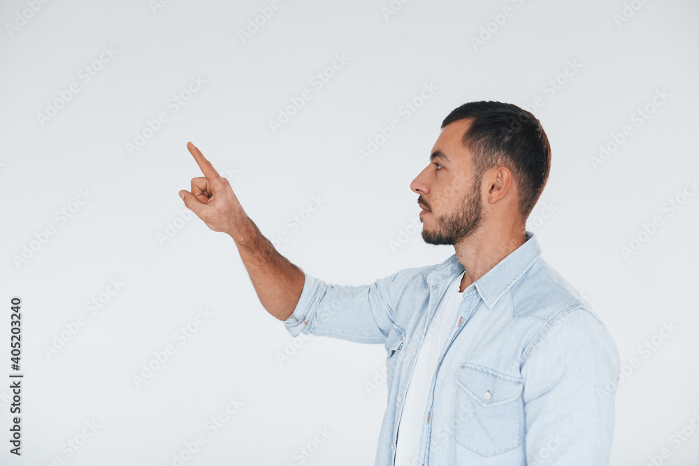 Young handsome man standing indoors against white background Young handsome man standing indoors against white background