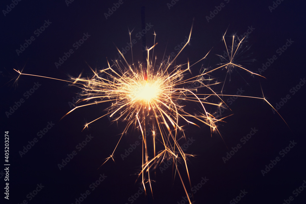 Close up of one burning pyrotechnic sparkler on dark background. Photo with magenta tint. Close up of one burning pyrotechnic sparkler on dark background. Photo with magenta tint.