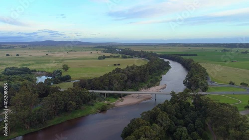 Slow rise over Snowy River and bridge revealing fields and hills in the distance photo