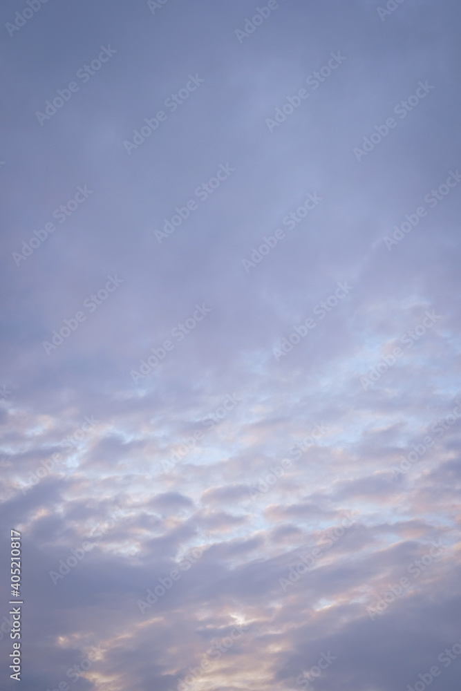 Vertical image of sunset clouds with blue sky in the evening.