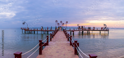 Fototapeta Naklejka Na Ścianę i Meble -  Sunset in Phu Quoc beach with nice view. Tourists, sunbeds and umbrellas on beautiful day in Sanato beach.