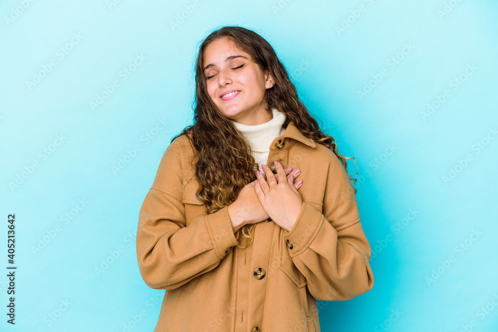 Young caucasian curly hair woman isolated has friendly expression, pressing palm to chest. Love concept. Young caucasian curly hair woman isolated has friendly expression, pressing palm to chest. Love concept.