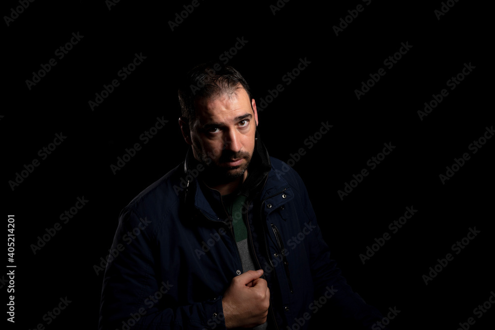 Attractive bearded man putting on a blue jacket posing isolated Attractive bearded man putting on a blue jacket posing isolated