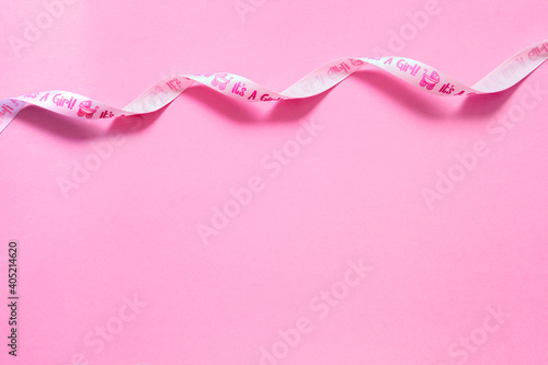 Fondo rosa con espacio libre para mensaje o foto del bebé. Cinta rosa decorativa.