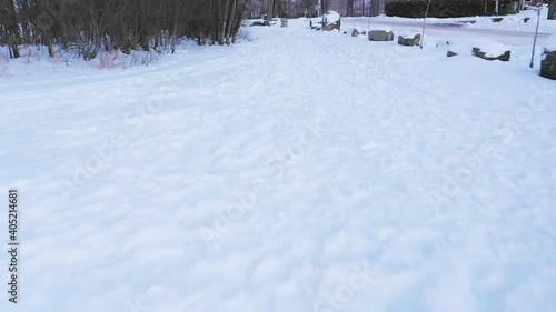 Wallpaper Mural very low drone shot backing up while following pedestrian tracks in the white snow by the street  Torontodigital.ca
