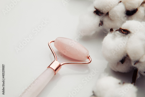 Pinl jade roller for face massage close-up. Anti age, lifting and toning treatment.