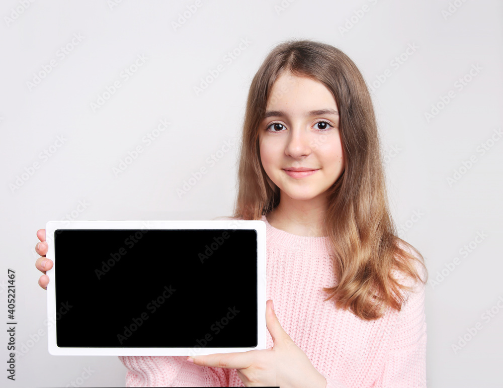 Caucasian child girl holding tablet,empty space blank promotional design image.Kid with screen closeup. Caucasian child girl holding tablet,empty space blank promotional design image.Kid with screen closeup.