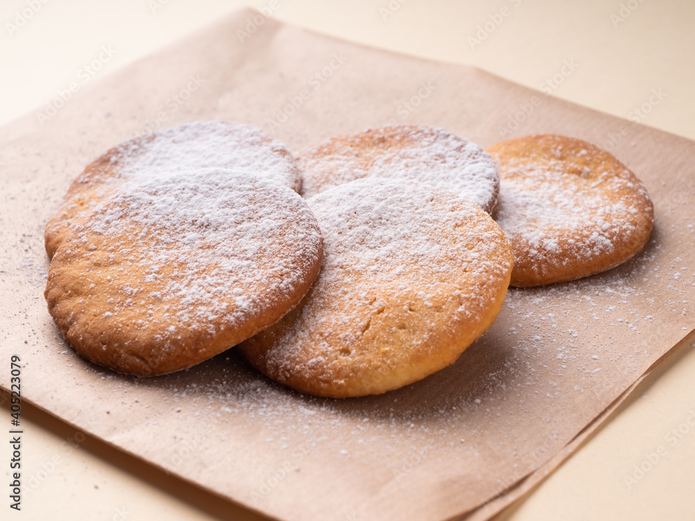 Delicious homemade shortbread cookies, in warm brown tones, close-up. Cookies in powdered sugar on a paper napkin