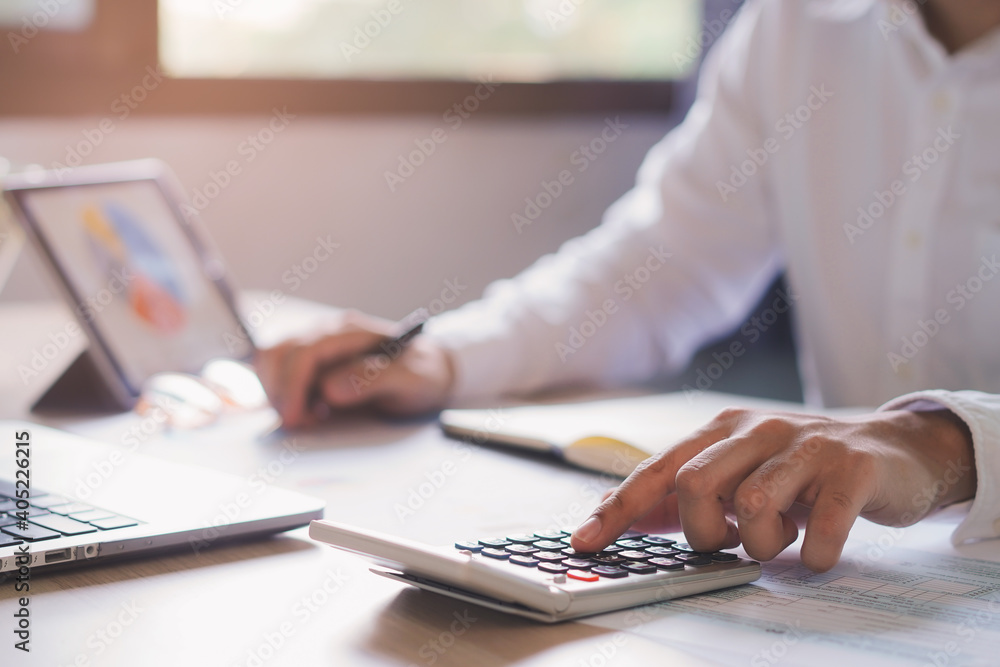 close up hands of accountant calculating tax refund using calculator close up hands of accountant calculating tax refund using calculator