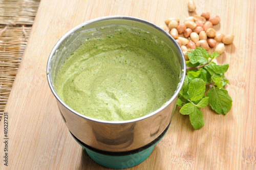 green mint chutney or dip with mint leaves aside