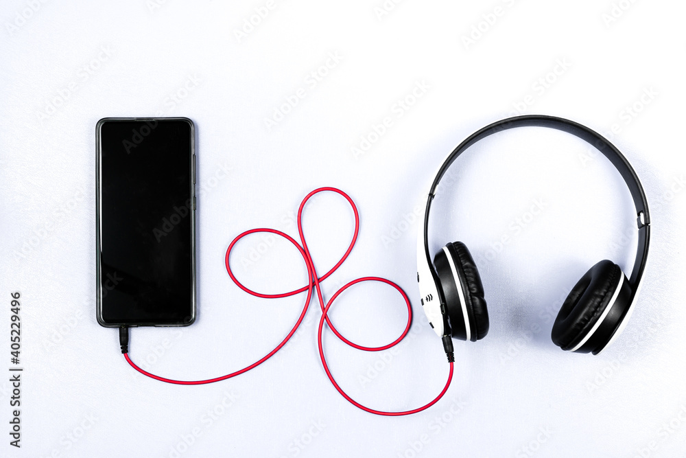 Headset and a phone on a white background. Ready to listen to music. Headset and a phone on a white background. Ready to listen to music.