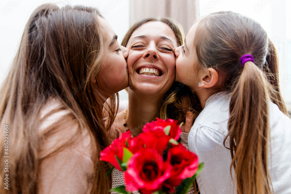 Happy mother receiving a gift from her daughters in living room - Mother's day concept. Happy mother receiving a gift from her daughters in living room - Mother's day concept.