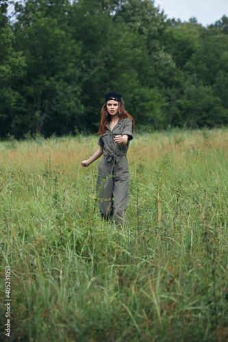 Woman on nature In a green jumpsuit, tall grass walk  © SHOTPRIME STUDIO