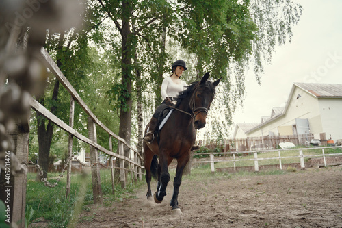 Cute girl with a horse. Lady in a white t-shirt. Woman in a summer ranch.