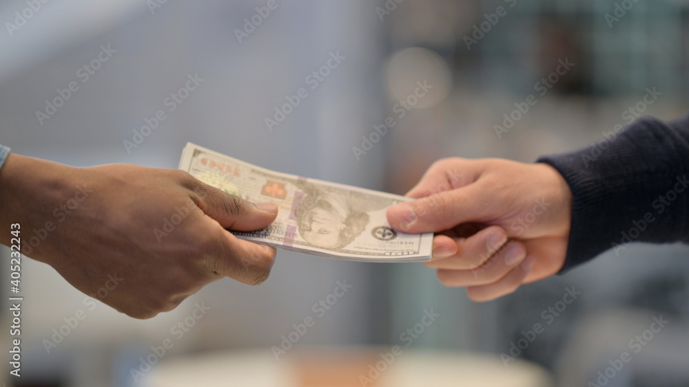 Close Up of African Man Taking Dollars from Caucasian Man 