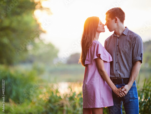 Romantic smiling couple in love dating at sunset at river.