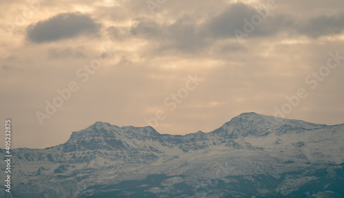 View of the highest peaks of Sierra Nevada (Granada, Spain) on a cloudy winter morning at sunrise